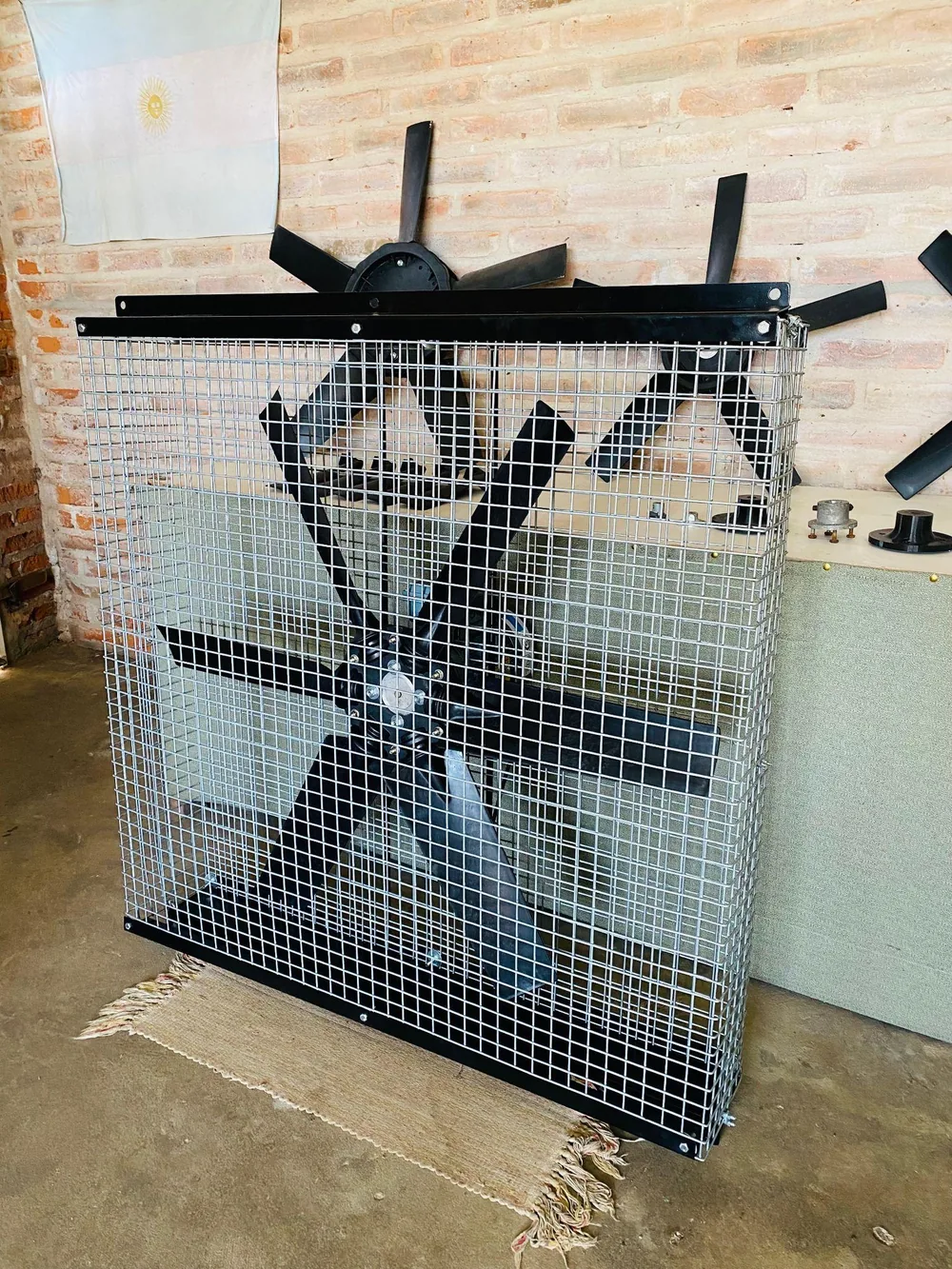 Circulador industrial de gran diámetro con bastidor y reja, visto en tres cuartos